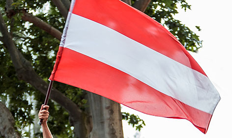 Mann schwingt Österreich-Fahne