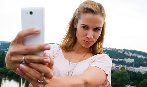 Frau schießt ein Selfie mit dem Handy