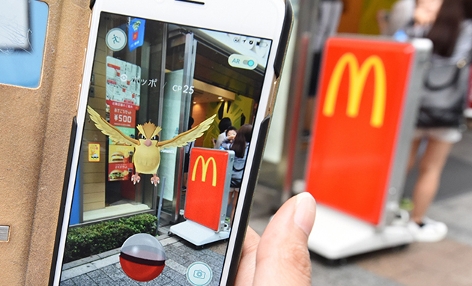 Eine Pokemonspielerin vor einer McDonalds-Filiale in Tokio