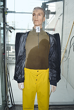 ein Dummy mit nasser Unterwäsche und Funktionsjacke im Regenturm