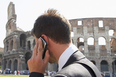 Mann telefoniert vor dem Kolosseum in Rom