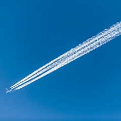 Kondensstreifen und ein Flugzeug am Himmel