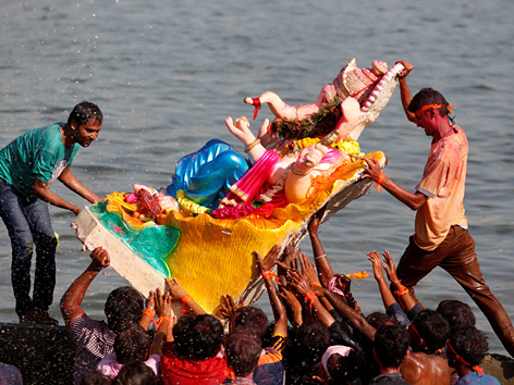 Hindus bringen eine Ganesha-Statue ins Wasser