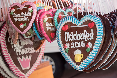 Lebkuchen-Herzen hängen an einem Verkaufsstand auf dem Wiesn-Gelände.