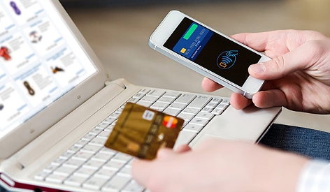 Ein Mann nutzt Smartphone und Kreditkarte um online einzukaufen