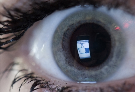 Auge in dem sich ein Facebook Logo spiegelt