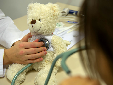 Ein Teddybär wird mit Stethoskop untersucht