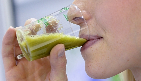 Eine Frau trinkt ein Smoothie mit Feldsalat