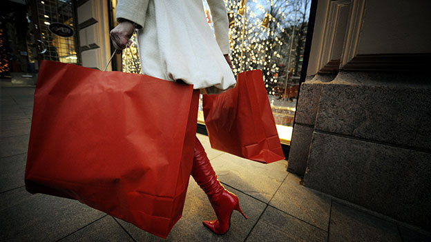 Frau trägt rote Taschen mit Geschenken