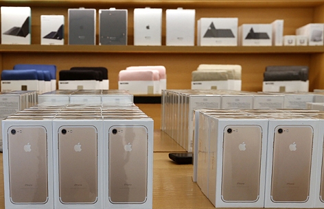 iPhone Schachteln auf dem Tisch eines Apples Stores in Dubai, im Hintergrund Regale mit Apple-Zubehör