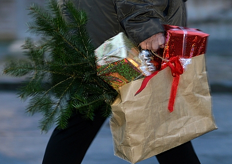 Eine Frau trägt Weihnachtseinkäufe