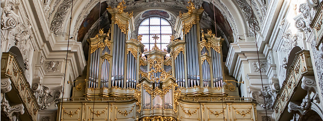 prächtig barocke Orgel in Gold, umgeben von weißem Marmor