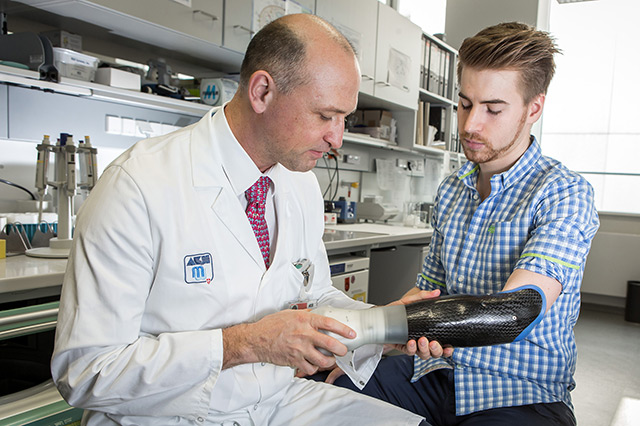 Oskar Aszmann mit legt einem Patienten die Armprothese an