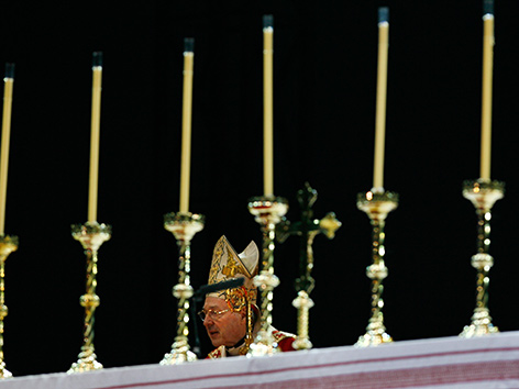 Kardinal George Pell hinter Kerzen auf einem Altar