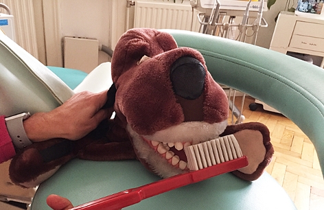ein Spielzeughund mit großen Zähnen und eine Riesenzahnbürste
