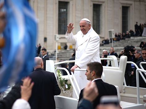 Papst Franziskus winkt aus dem Papamobil