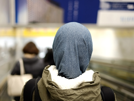 Eine junge Frau mit Kopftuch auf einem Flughafen