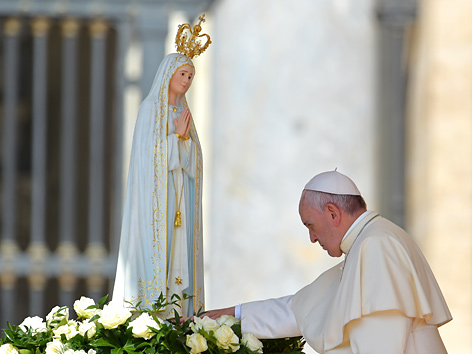 Papst Franziskus berührt eine Statue der heiligen Madonna von Fatima