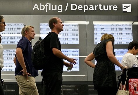 Flugpassagiere vor den Check-In Schaltern des Flughafen Wien-Schwechat