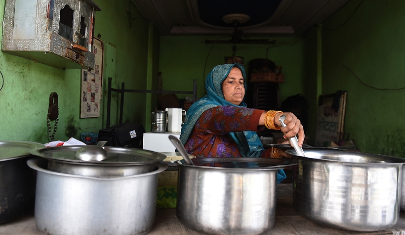 Indian 'dhaba' - restaurant - owner, Santosh
checks containers of curries at her dhaba on the outskirts of New
Delhi