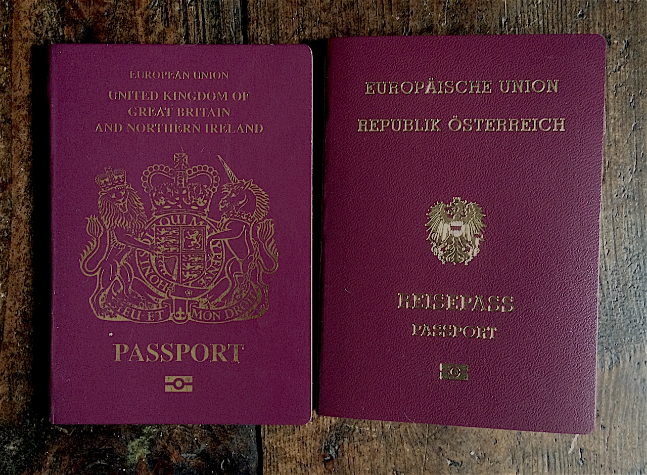 Ein britischer und ein österreichischer Reisepass nebeneinander