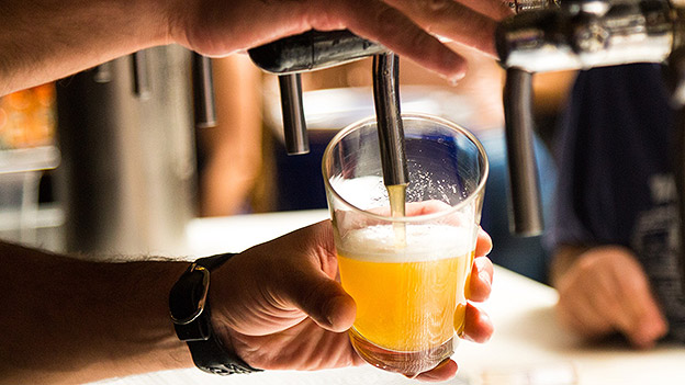 Bier wird in ein Glas gezapft.