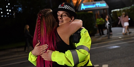 Eine Zuschauerin umarmt beim One Love Manchester Benefiz eine Polizistin