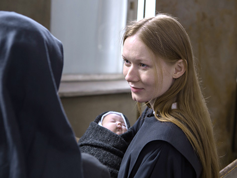 Filmstill aus "Agnus Dei": Eine junge Ordensfrau hält ein Neugeborenes im Arm