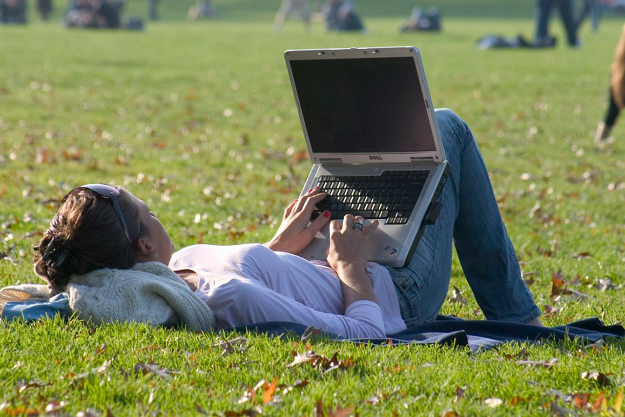 Frau im Park mit Laptop