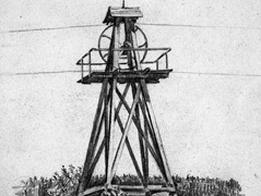Drahtseilantrieb: Drähte übertragen den von einem Wasserrad produzierten Strom über eine Masten-Rad-Konstruktion bis zu Pichlers Mühle