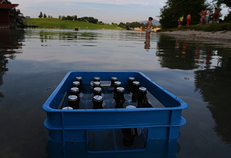 Eine Bierkiste steht zur Abkühlung im See
