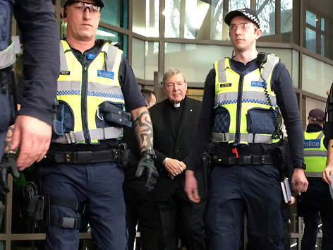 Kardinal George Pell kommt aus dem Gericht in Melbourne, von Sicherheitsleuten flankiert