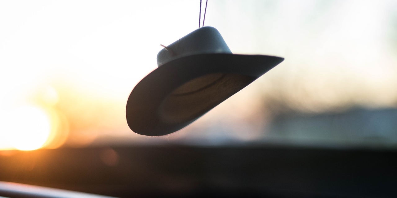 Ein Hut, der hinter einer Auto-Windschutzscheibe hängt.