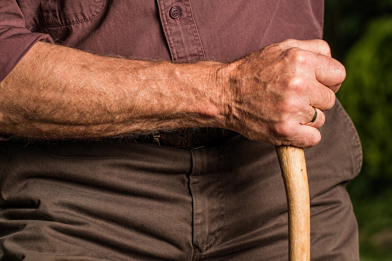 Rumpf und Arm eines alten Mannes mit Gehstock