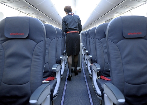 Eine Flugbegleiterin geht durch leere Sitzreihen einer Boeing 737-800 von Air Berlin
