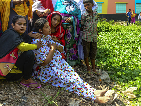 Trauende Angehörige bei der zerstörten Textilfabrik in Dhaka, Bangladesch