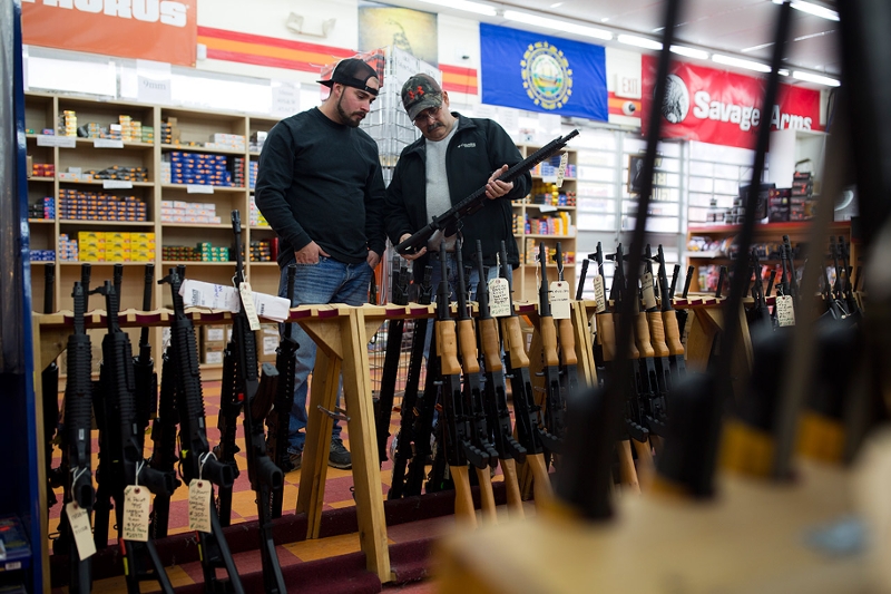 Customers look at a long gun at a gun shop on November 5, 2016, in Merrimack, New Hampshire