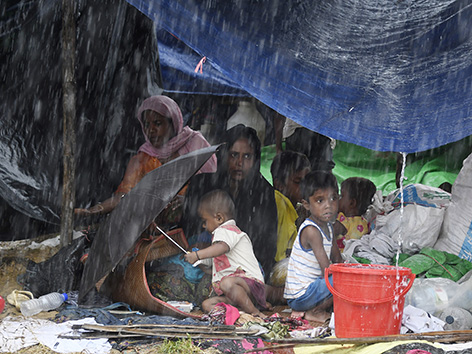 Angehörige der muslimischen Minderheit Rohingya im Flüchtlingscamp in Cox’s Bazar in Bangladesch, die unter Planen Schutz vor dem Regen suchen