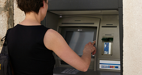Frau hebt Geld an einem Bankomaten ab