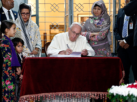 Papst Franziskus trägt sich in das Gästebuch der Gedenkstätte in Sabhar, Bangladesch, ein