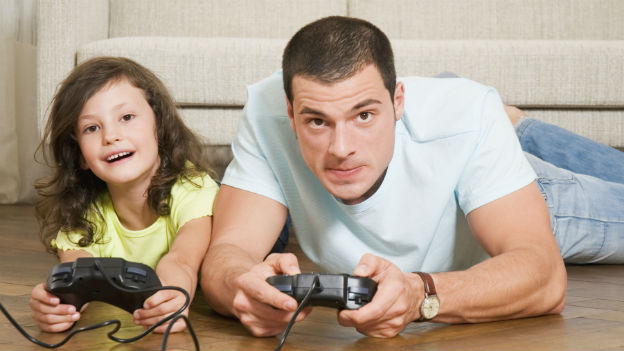 Vater und Tochter spielen gemeinsam ein Videospiel