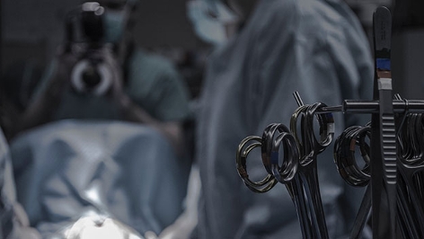 Operationsbesteck in einem OP, Chirurgen unscharf im Hintergrund
