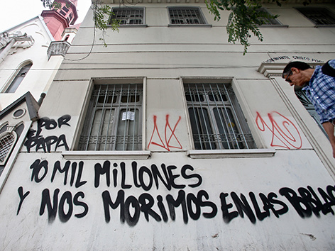 Eine Hauswand mit einem Graffiti in spanisch: "10 Millionen für den Papst und wir sterben in unseren Städten"
