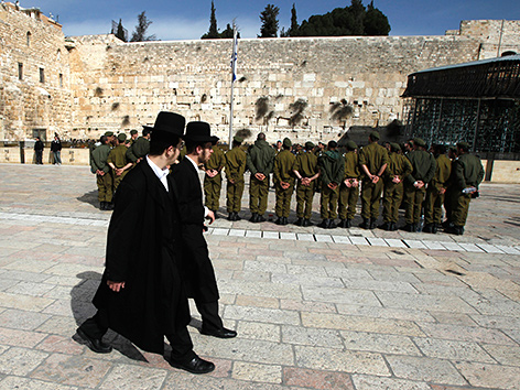 Ultraorthodoxe Männer gehen an einer Gruppe israelischer Soldaten vor der Klagemauer in Jerusalem vorbei