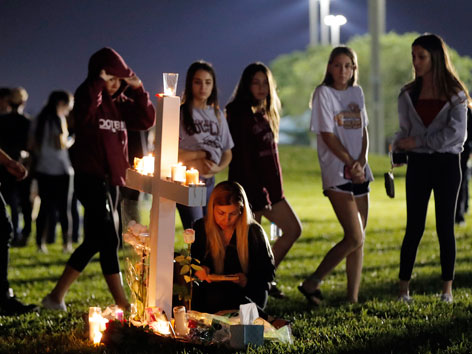 Jugendliche bei einem von 17 aufgestellten Kreuzen mit Kerzen für die Opfer des Schulmassakers in Florida
