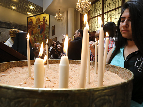 Orthodoxe Christin in Syrien zündet Kerzen an