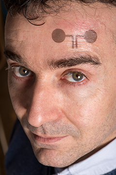 Forscher Francesco Greco trägt ein medizinisches "Klebe-Tattoo" auf der Stirn