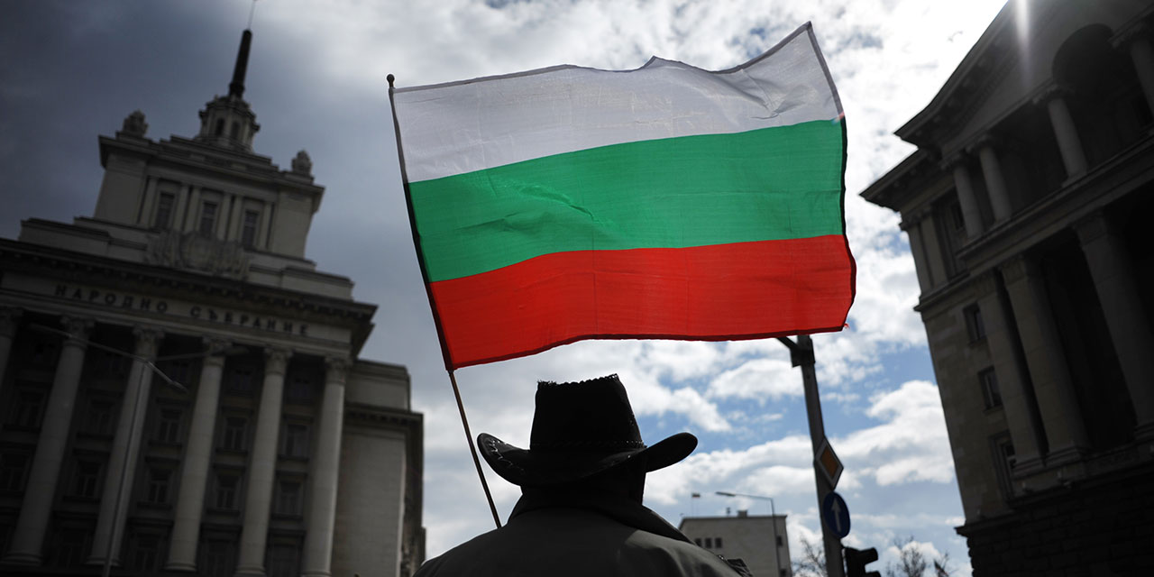 Mann mit bulgarischer Fahne vor dem Sitz der Regierung