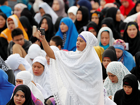 Frauen feiern das Ramadan-Ende mit Gebet in einem Parkin Manila, Philippinen