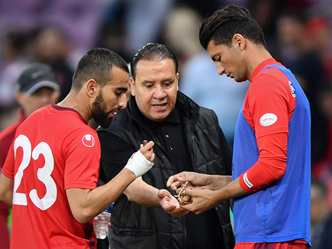 Der Tunesische Coach Nabil Maaloul reicht zwei seiner Spieler Datteln
